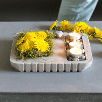 Bricka i betong med blommor och ljus
